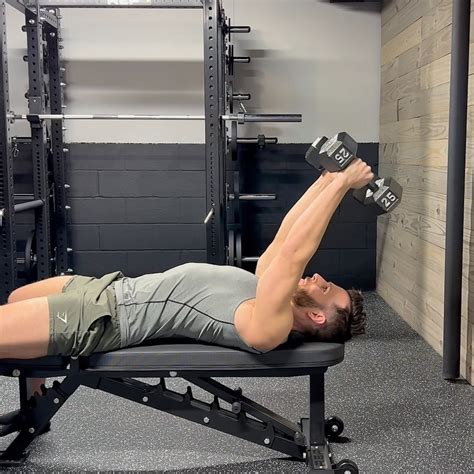 Lie in a supine position on the bench with your feet on the floor and one dumbbell in hand. Start with your single arm extended with the dumbbell straight o...